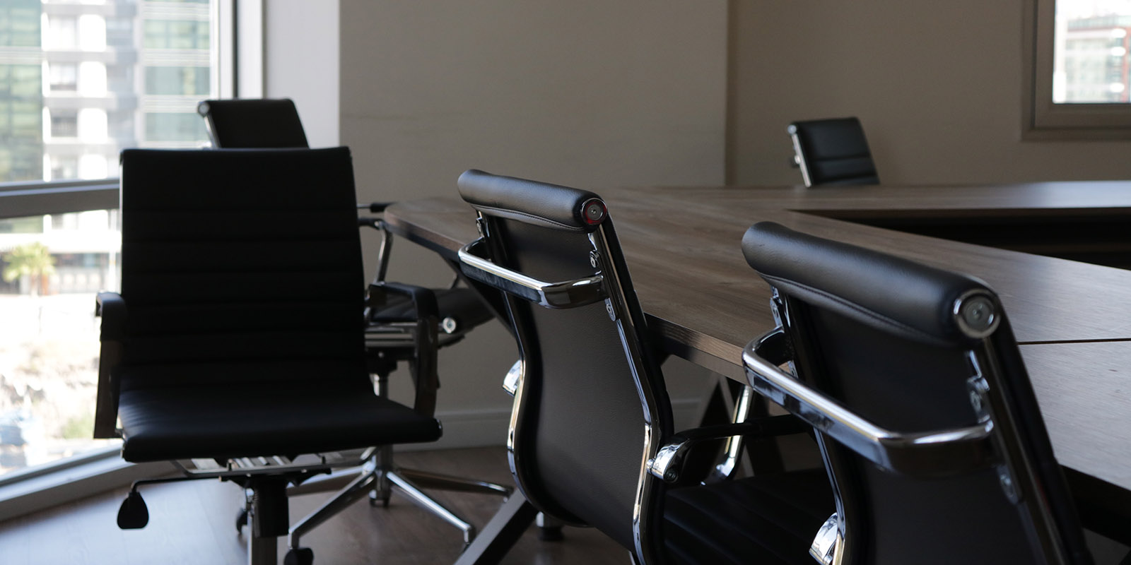 Dark wooden boardroom table and black blardroom chairs