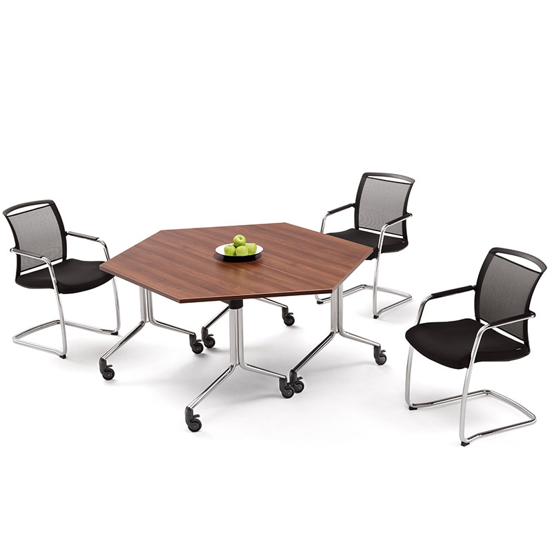 Three black office chairs around a hexagonal brown table with a plate of apples on it