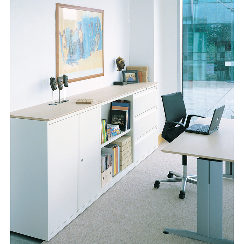 Office with white filing cabinet and storage, and a black chair next to a desk